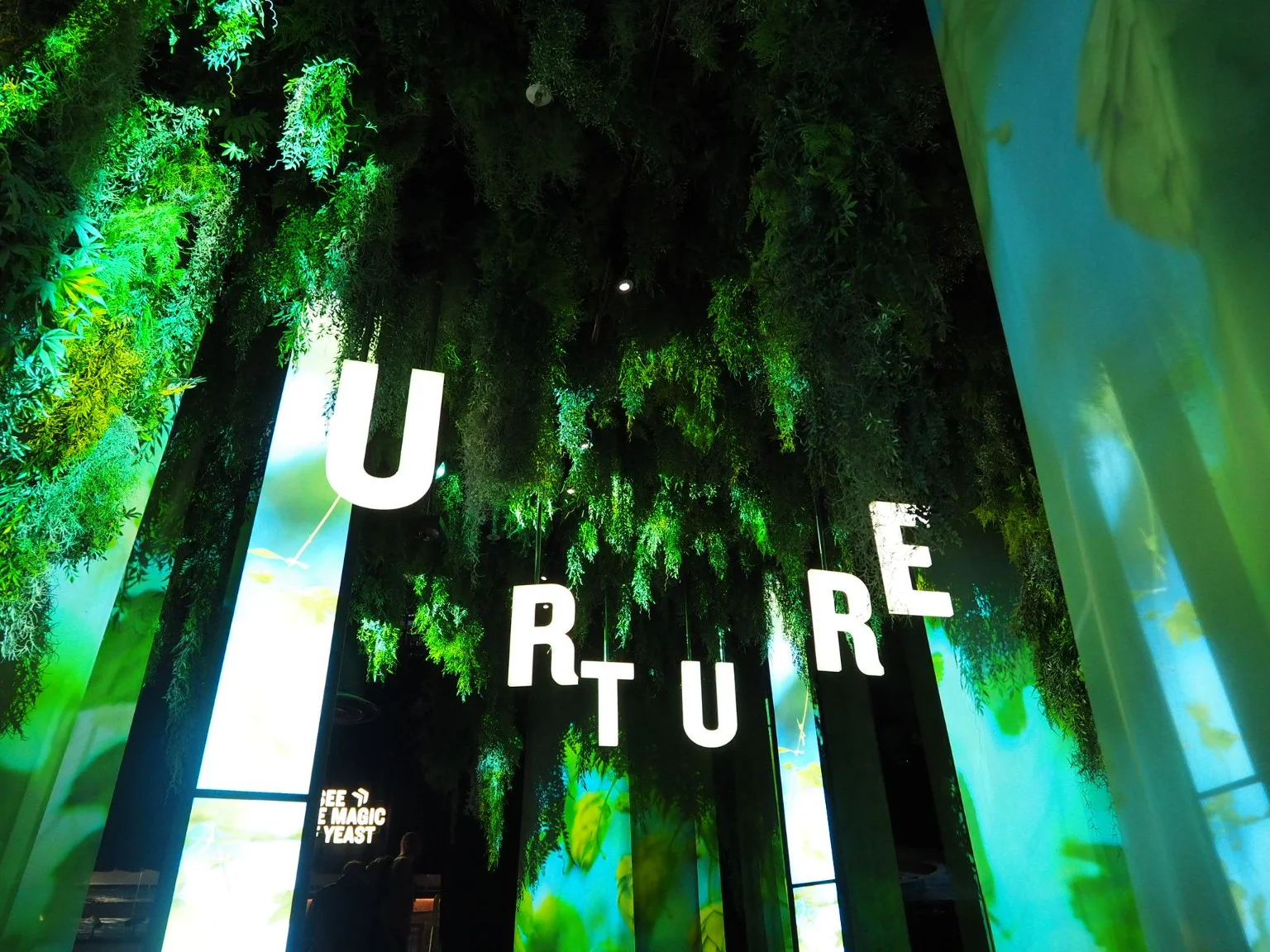 Large illuminated letters and green scenery in the Storehouse exhibition.